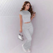 Woman wearing gray crop top and low rise flare leggings yoga pants set activewear