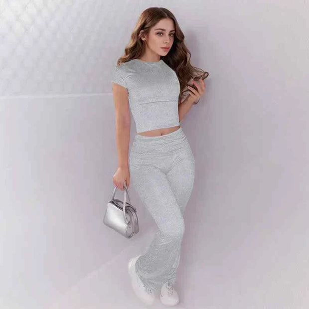 Woman wearing gray crop top and low rise flare leggings yoga pants set activewear