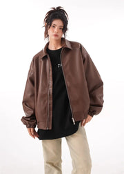Brown faux PU leather rider jacket for women with long sleeves and a zipper closure, styled with a black top and beige pants.