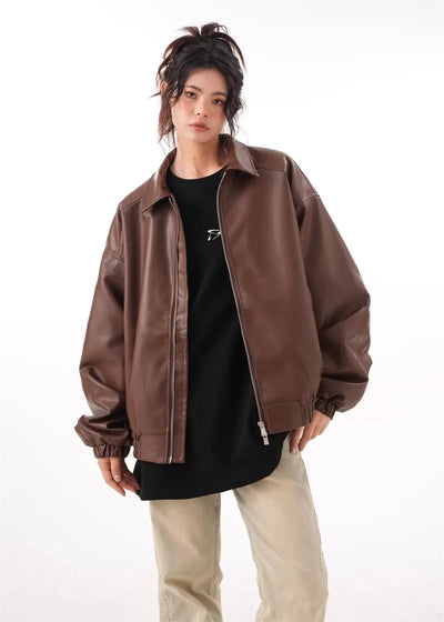 Brown faux PU leather rider jacket for women with long sleeves and a zipper closure, styled with a black top and beige pants.