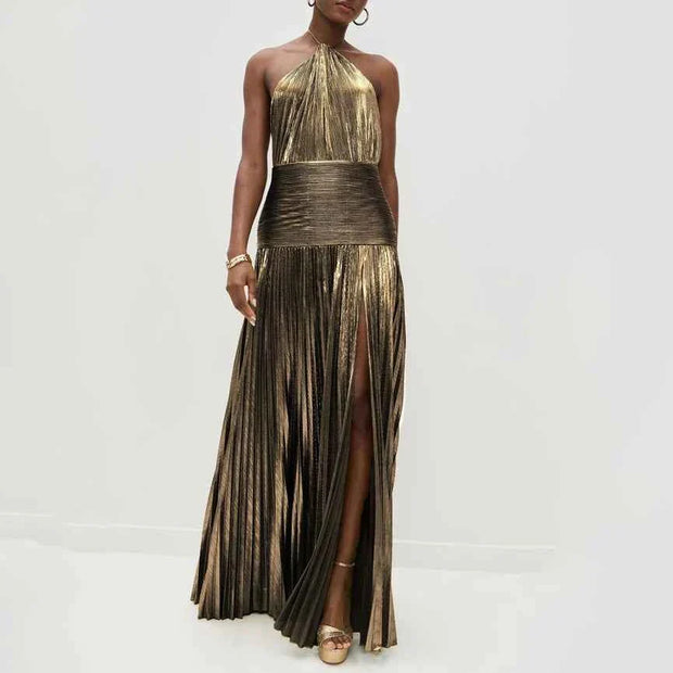 woman wearing sleeveless backless halter neck pleated metallic gold evening maxi dress with high slit