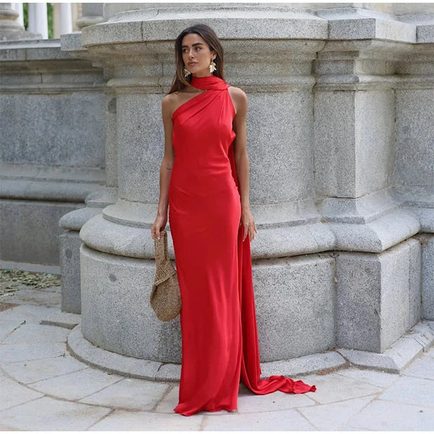 Woman wearing a red halter backless off shoulder sleeveless ankle-length dress with a diagonal collar and slim fit