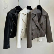 Three vintage style women's faux leather jackets in black, white, and brown with zipper closures and turn-down collars hanging on hangers.