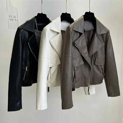 Three vintage style women's faux leather jackets in black, white, and brown with zipper closures and turn-down collars hanging on hangers.