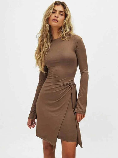 Woman wearing brown long sleeve bodycon dress with side bandage detail and O-neck design.