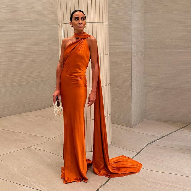 Slim fit halter backless orange off shoulder sleeveless ankle-length gown made of polyester with diagonal collar and zipper closure.