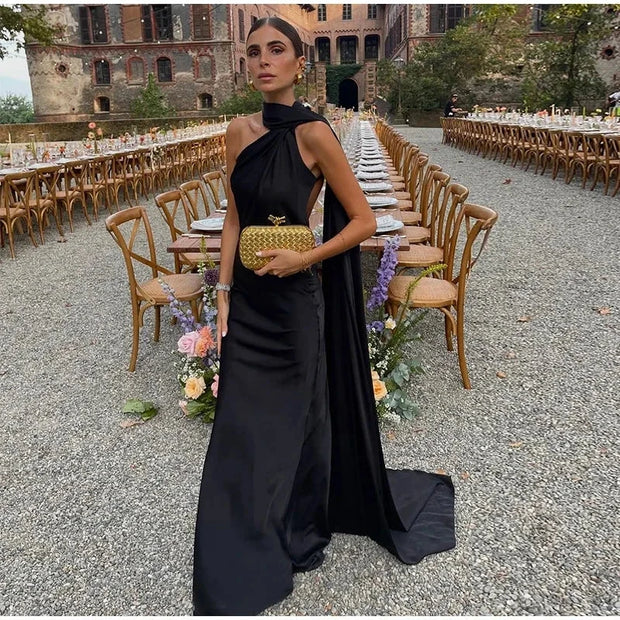 Elegant black halter backless off shoulder sleeveless ankle-length gown with slim fit and diagonal collar neckline.