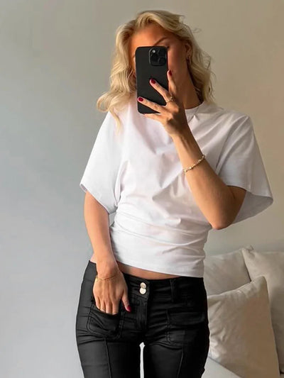woman wearing white casual solid streetwear short sleeve tee and black pants taking mirror selfie