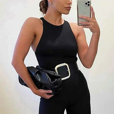 Woman wearing a black summer sexy sleeveless slim-fit bodysuit taking a mirror selfie with a black clutch and wide belt