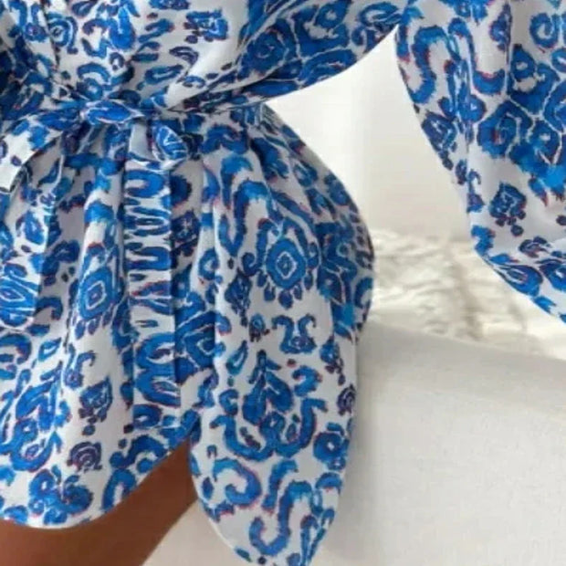 Blue and white printed asymmetrical women's casual dress with lantern sleeves and waist tie detail