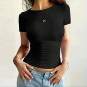 Black solid summer fashion tee with short sleeves and slim fit on female model wearing light blue jeans