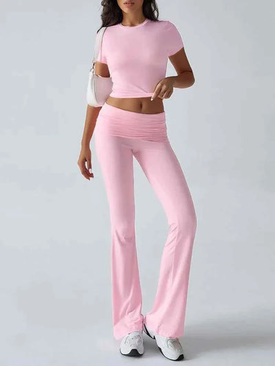 woman wearing pink casual solid color yoga suit slim fit short sleeve top and high waist flared pants