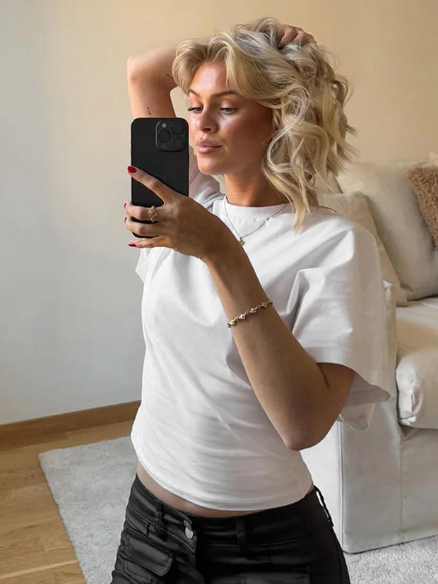 Woman wearing white O-neck corset streetwear short tee top taking a mirror selfie