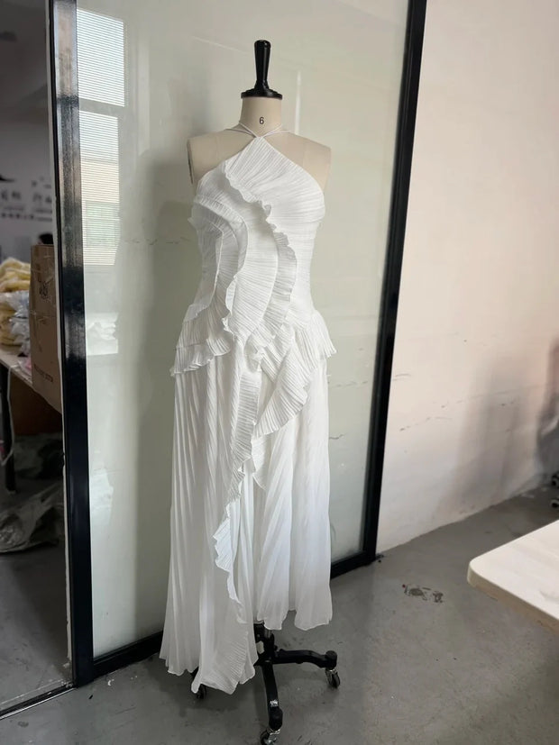 White slim fit backless halter dress with lace-up detail and ruffled design on mannequin