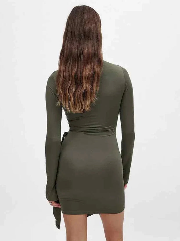 Woman wearing olive green long sleeve bodycon dress with side bandage detail, back view